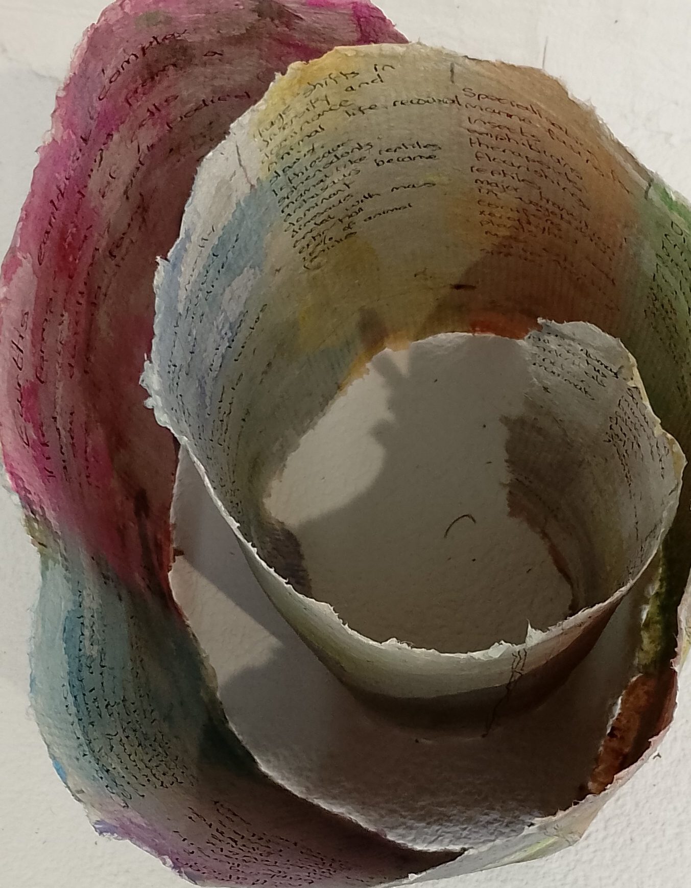 Hand made paper coiled, with text and images.